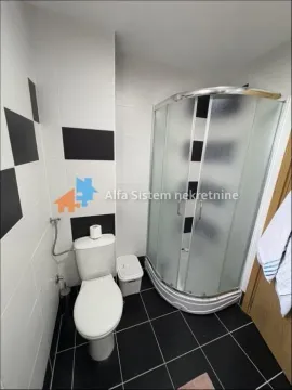Kupatilo opremljeno tuš kabinom, toaletom i crno-belim pločicama. - image 13