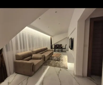 Spacious living room with a sofa set, dining area, and modern lighting. - image 12