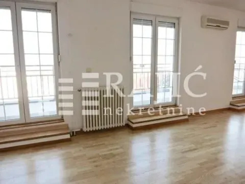 Spacious empty room with parquet flooring and balcony doors. - image 7