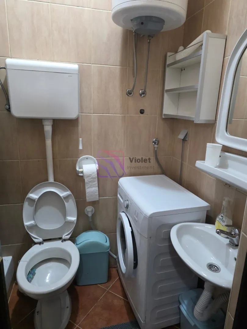 Manje kupatilo opremljeno toaletom, umivaonikom i veš mašinom.
