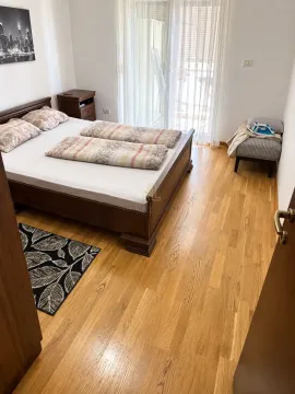 Spavaća soba sa bračnim krevetom, drvenim podom i izlazom na terasu. - image 6