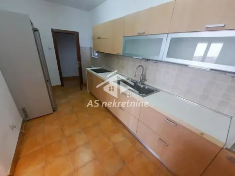 Kuhinja sa drvenim elementima, sudoperom i frižiderom. - image 4