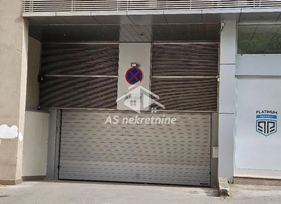 Ulaz u garažu sa rolo vratima na zgradi.