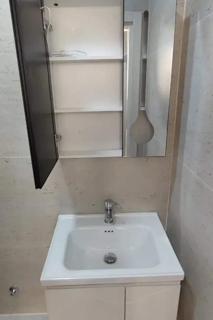 Bathroom with a washbasin, cabinet, and mirror.