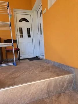 Entrance to the house with tiled stairs and white doors. - image 11