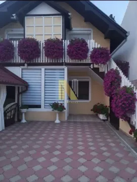 Eksterijer kuće sa popločanim dvorištem i balkonom ukrašenim cvećem. - image 3