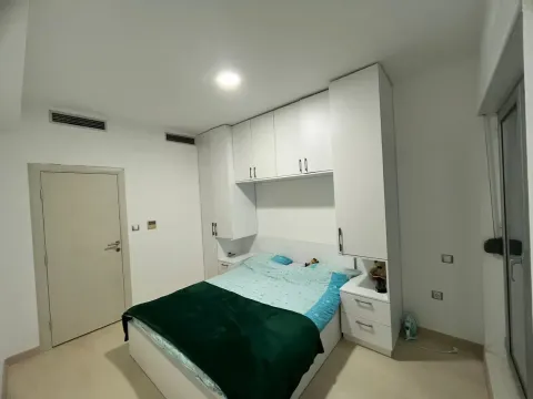 Bedroom with a double bed and built-in white wardrobes. - image 9