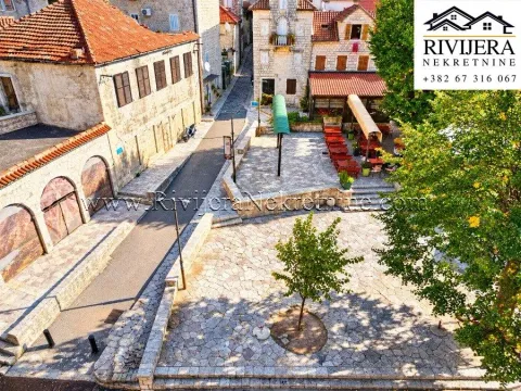 Aerial view of the paved square in front of traditional stone houses and restaurants. - image 6