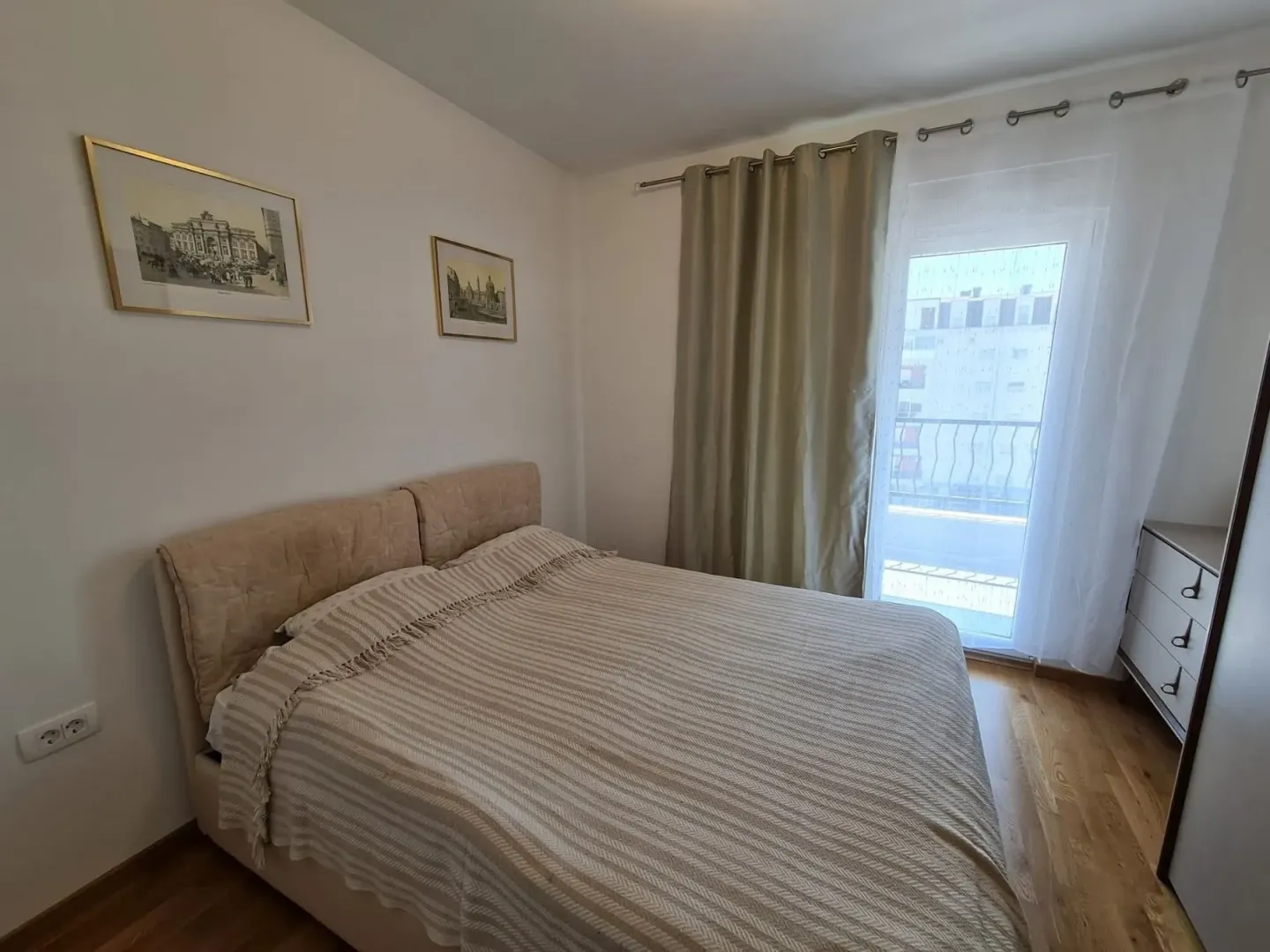 Bright bedroom with a double bed and access to the balcony.