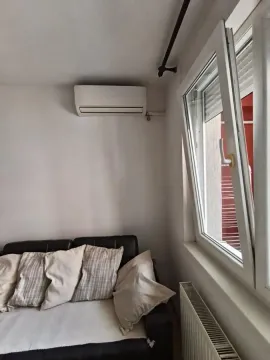 Pogled na deo dnevnog boravka sa kaučem, klima-uređajem i otvorenim prozorom. - image 22
