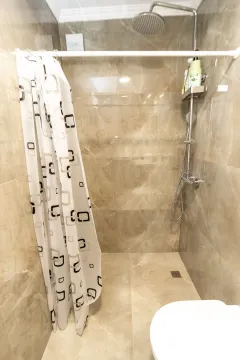 Modern tiles and a shower cabin with a curtain in the bathroom. - image 10