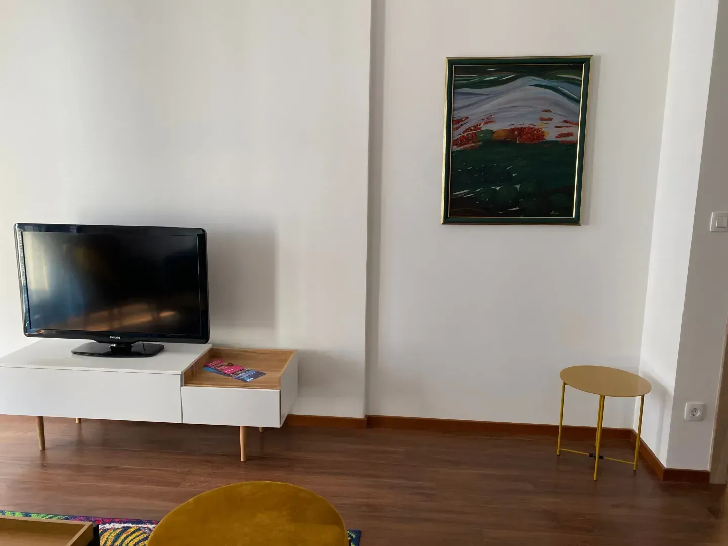 Living room with a TV unit and a painting on the wall.