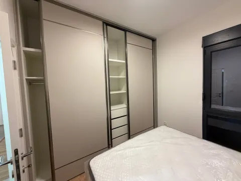 Spavaća soba sa velikim ugradnim garderoberom i krevetom. - image 6
