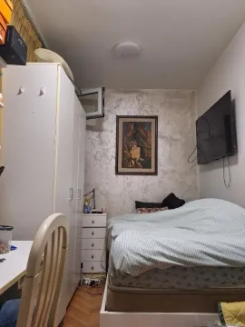 A small, functional bedroom with a double bed, wardrobe, and wall-mounted TV. - image 4