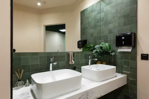 Modern double washbasins with green tiles in the bathroom. - image 16