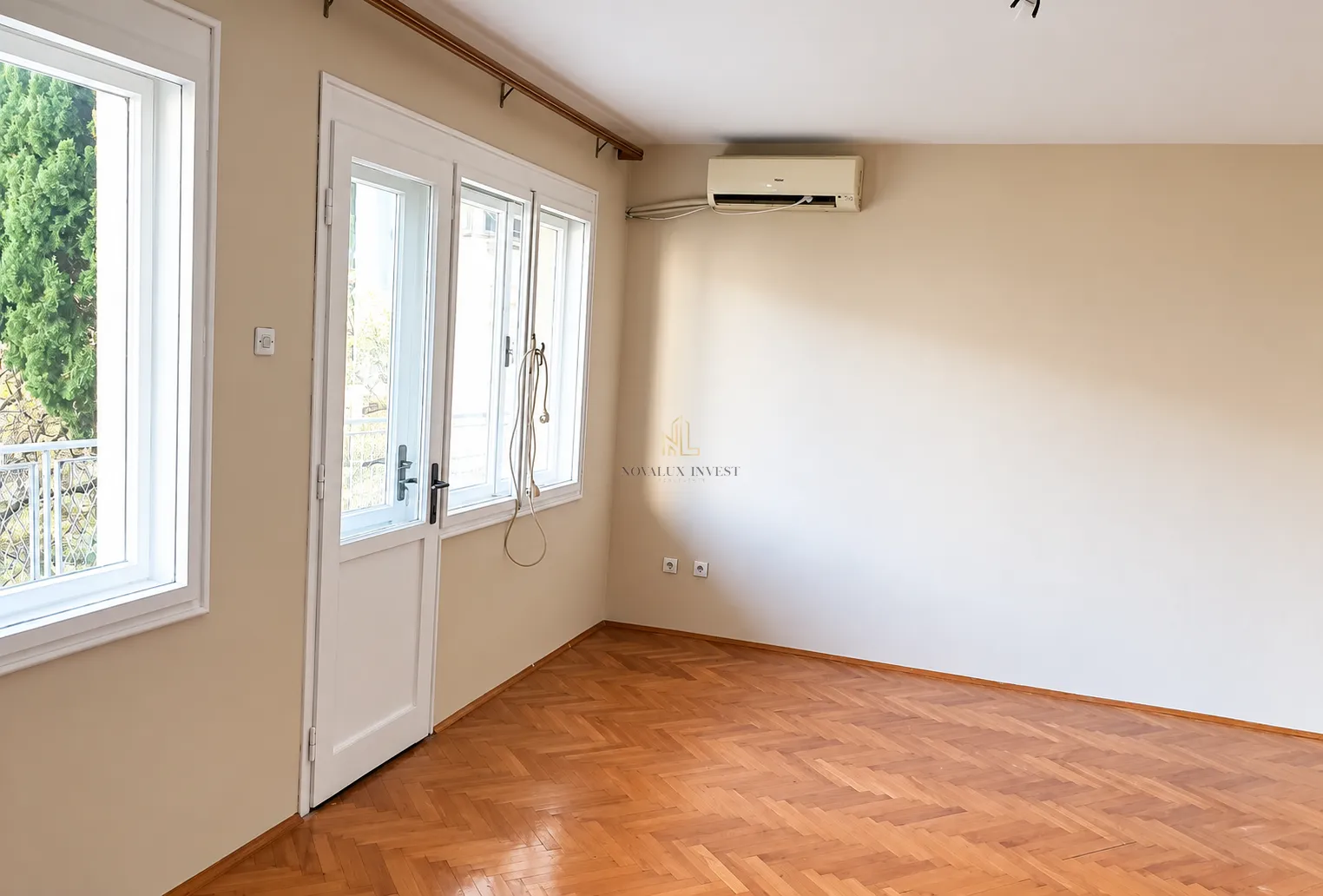 Empty room with parquet flooring, an air conditioning unit, and a door leading to the terrace.