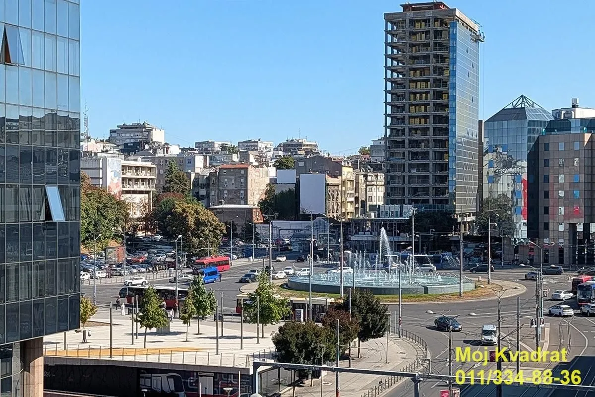 Pogled sa prozora na gradski trg i saobraćajnicu.