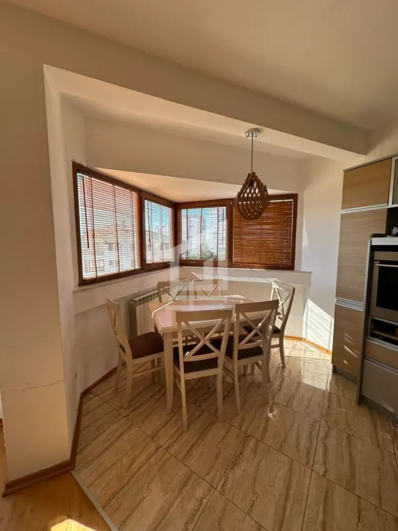 Kitchen with a dining table and chairs near the windows.