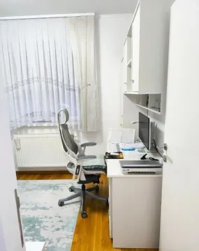 Radna soba sa radnim stolom, računarom i belim nameštajem. - image 12