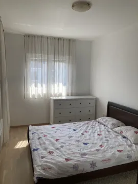 Bright bedroom with a double bed, white dresser, and window. - image 5