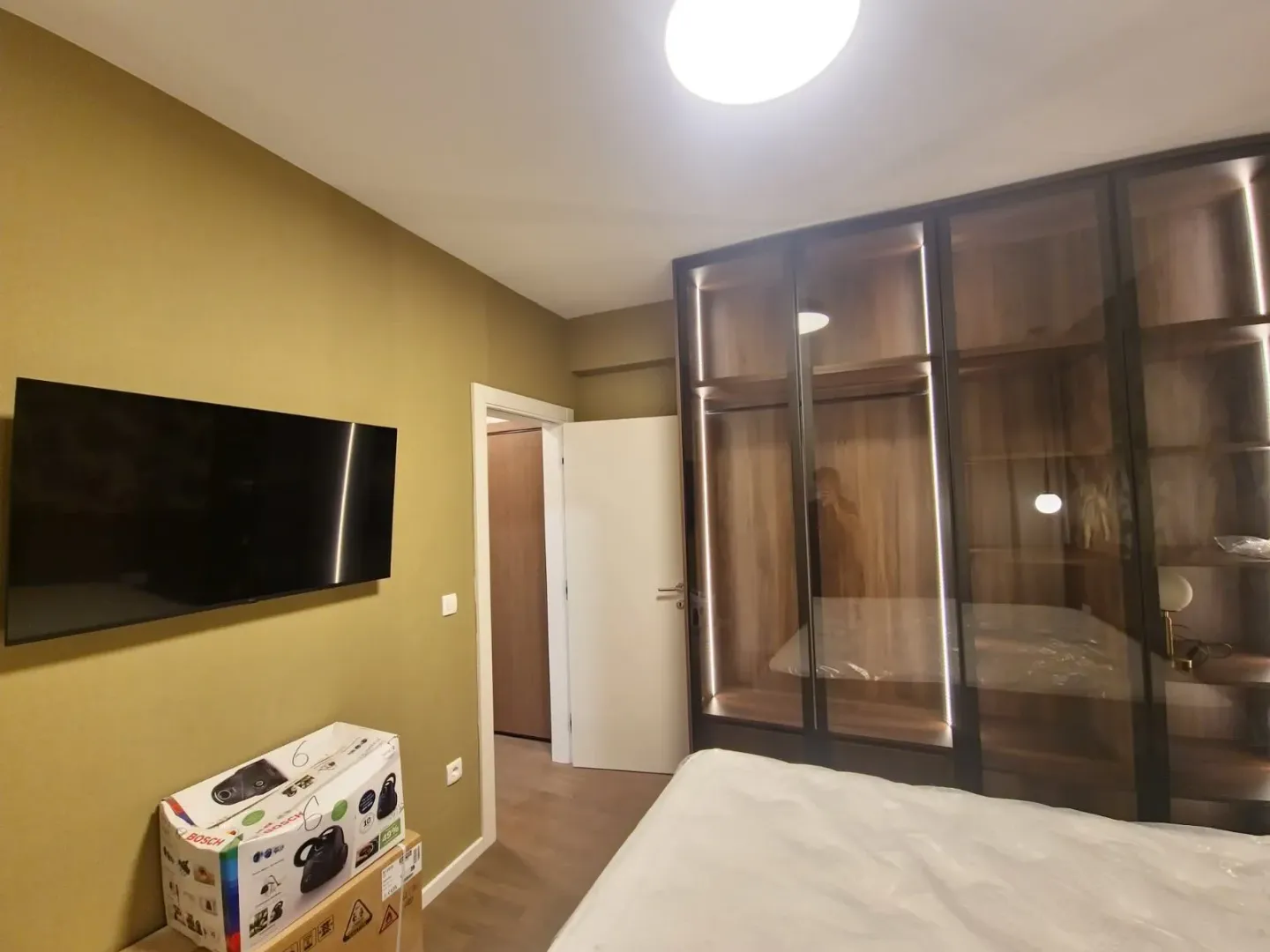 Bedroom with a large built-in wardrobe and a wall-mounted TV.