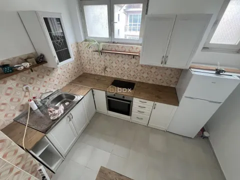 Compact white kitchen with wooden countertop and built-in stove. - image 4
