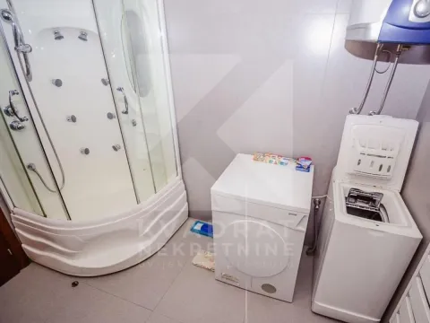 Bathroom with a shower cabin and washing machines. - image 3
