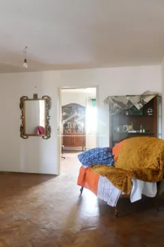 Dnevna soba sa foteljom, ogledalom na zidu i pogledom u drugu prostoriju. - image 15