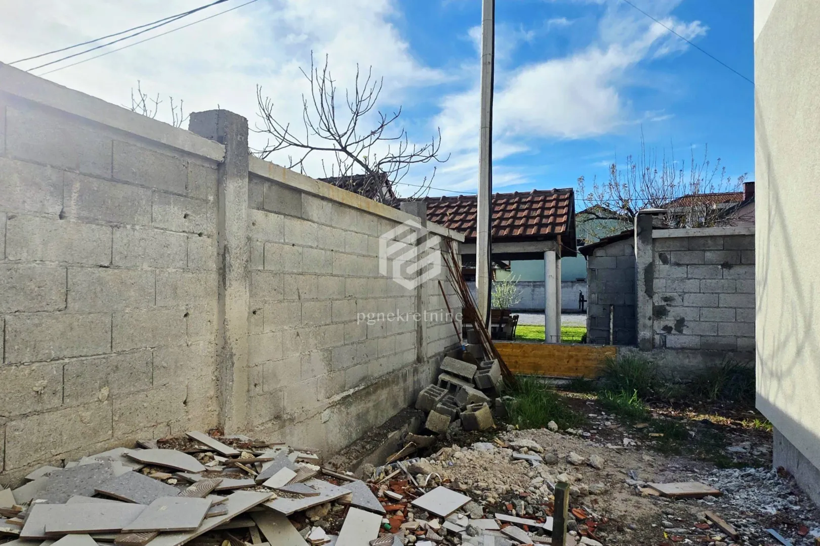 Pogled na dvorište i okolne objekte sa gomilom građevinskog otpada.