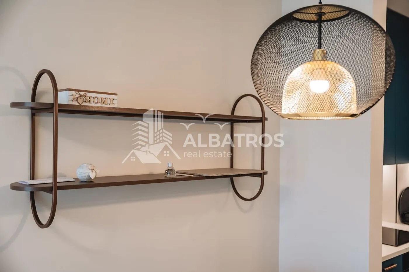 Interior detail showing a wall shelf and a modern pendant lamp.