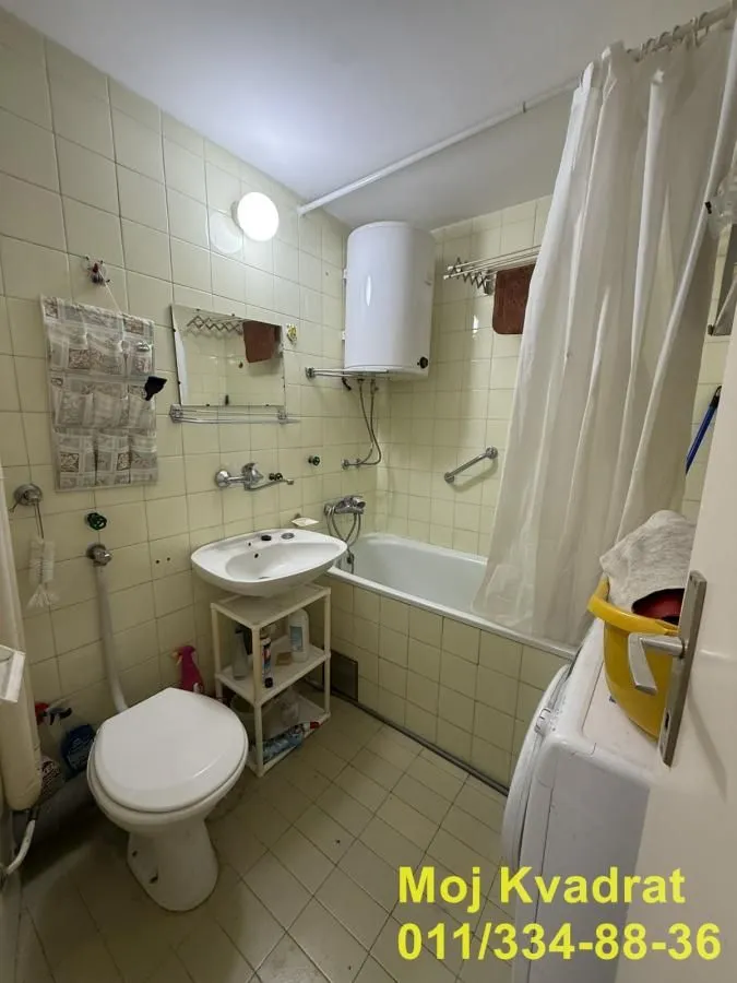Manje opremljeno kupatilo sa kadom, umivaonikom i wc šoljom.