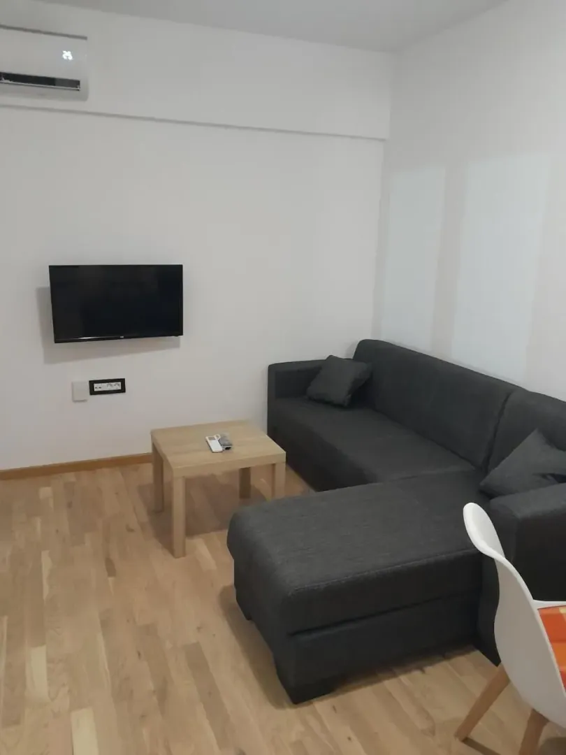 Living room with a sectional sofa, coffee table, and wall-mounted TV.