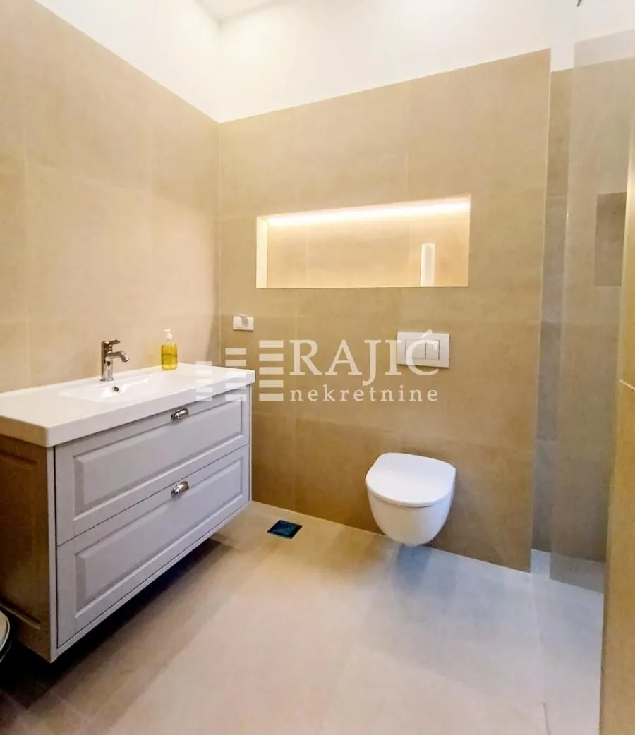 Modernly equipped bathroom with a vanity and built-in toilet.