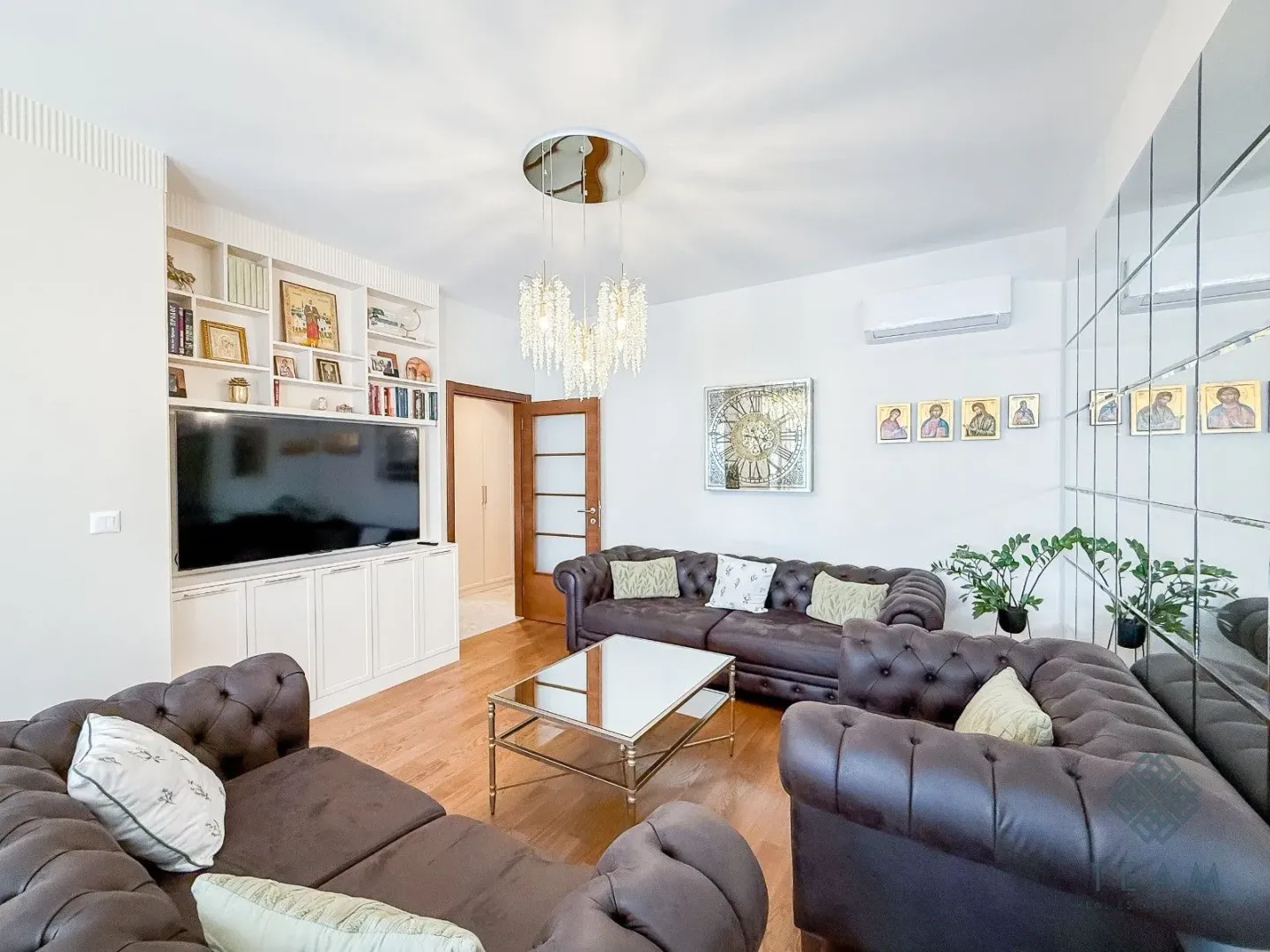 Living room with a sofa set, television, and built-in shelving.