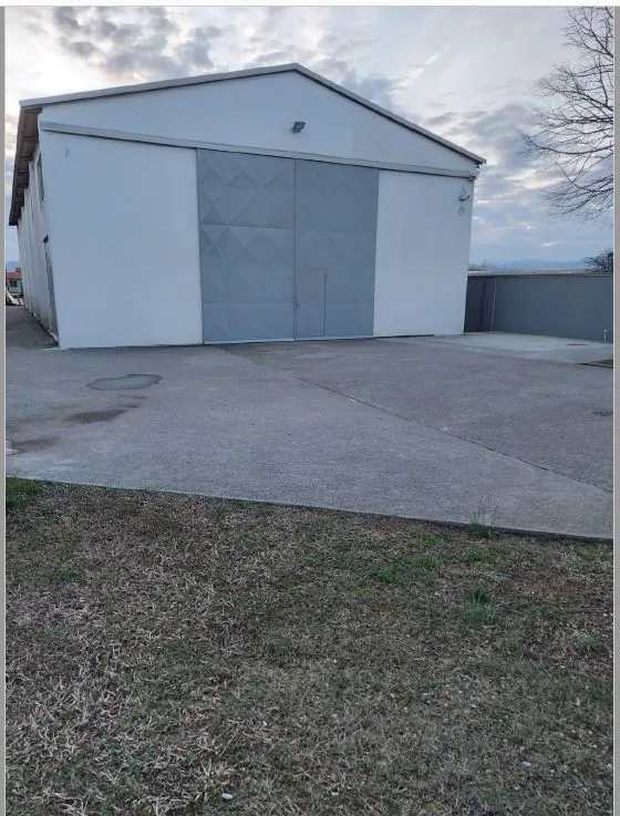 Exterior of a warehouse with large metal doors and an access area.