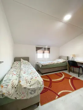 Bedroom with two beds and a desk. - image 6