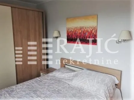 Furnished bedroom with a double bed and a fitted wardrobe.