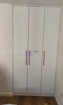White three-door wardrobe with metal handles in the room. - image 4