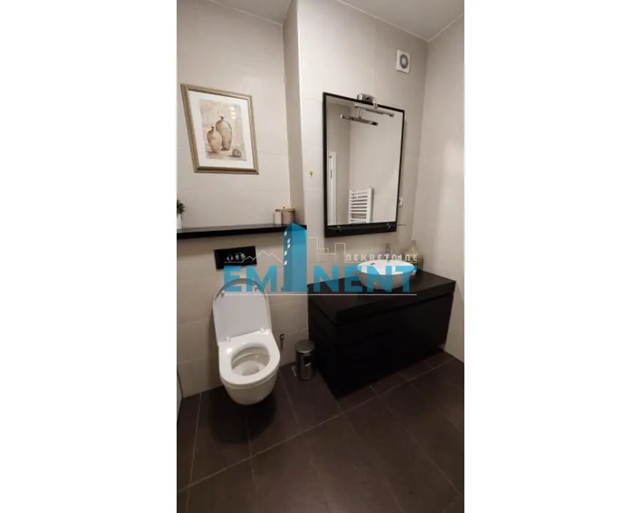 Modernly equipped bathroom with sanitaryware in dark tones.