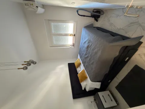 Bright bedroom with a double bed, nightstand, and window. - image 3