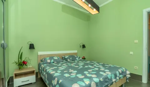 Spavaća soba sa bračnim krevetom i zelenim zidovima. - image 25