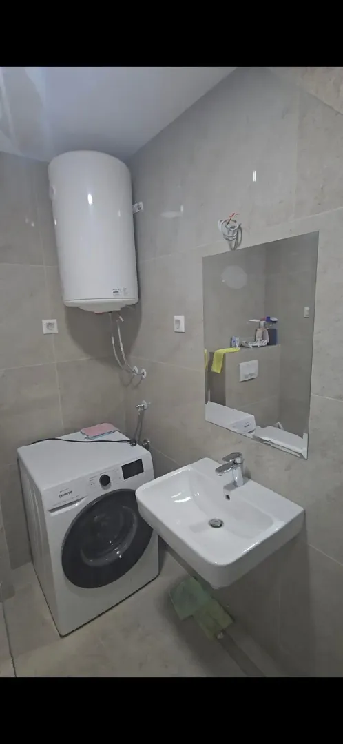 Manje kupatilo sa umivaonikom, veš mašinom i bojlerom.