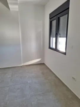 Prazna svijetla prostorija sa sivim pločicama i prozorom. - image 6
