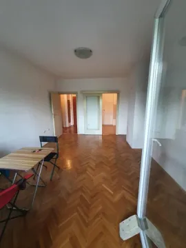 Prazna soba sa drvenim parketom i trpezarijskim stolom. - image 3
