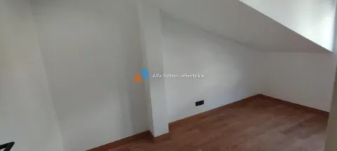Prazna potkrovna prostorija sa belim zidovima i drvenim podom. - image 12