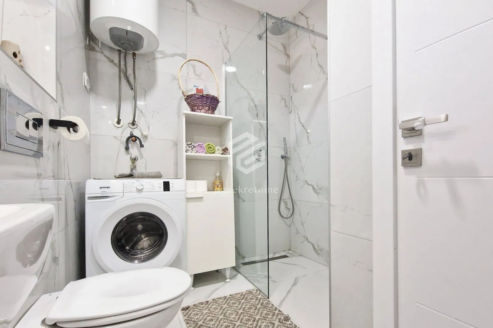 Modern bathroom with a walk-in shower, toilet and washing machine.