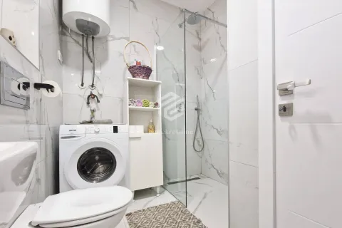 Modern bathroom with a walk-in shower, toilet and washing machine. - image 9