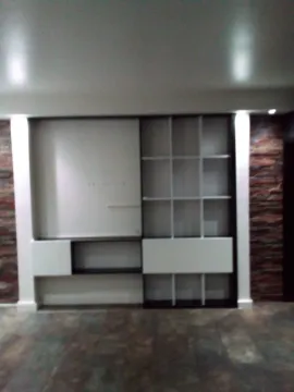 Built-in shelving unit and TV space in an empty room. - image 6