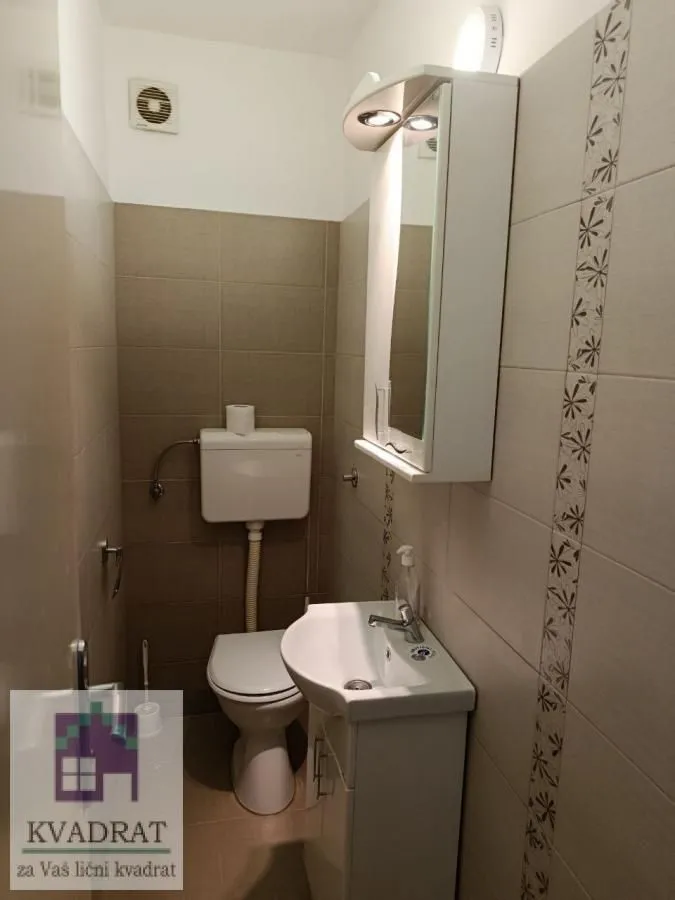 Manje kupatilo sa umivaonikom, ormarićem sa ogledalom i WC šoljom.