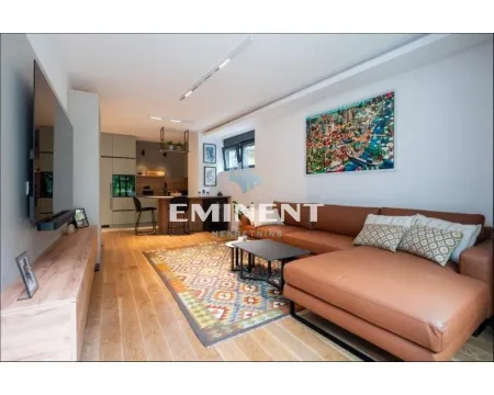Living room connected with the kitchen, equipped with a large leather sofa and a TV. - image 4